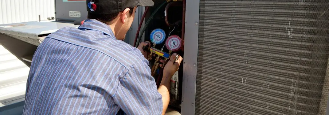 HVAC technician servicing a condenser unit in Lake Bluff